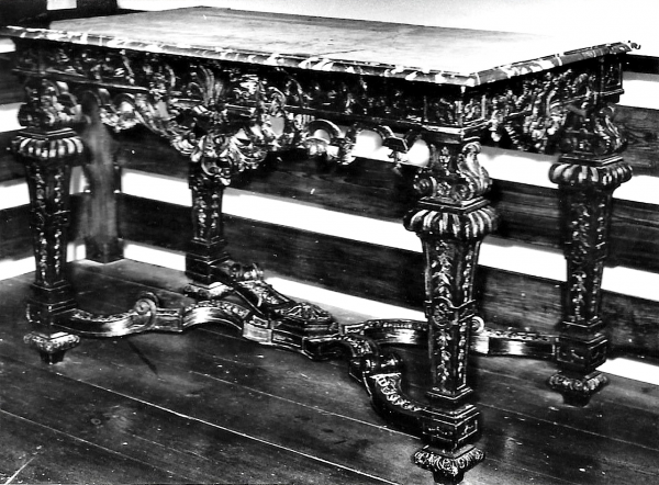 Stół - konsola, orzechowy w typie Ludwika XIV, prostokątny na czterech rzeźbionych nogach, połączonych w dołu rzeźbionym, giętym krzyżakiem. Blat marmurowy, klejony o wymiarach 74x133 cm. 
