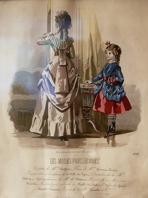 Rysunek kobiety w sukni z tiurniurą, stojącej tyłem. Obok postaci - dziewczynka w niebiesko-różowym stroju. Obie postacie stoją przy stoliku. W tle lustra i kotary. Pod ryciną dane autorów projektu oraz paginacja 1358