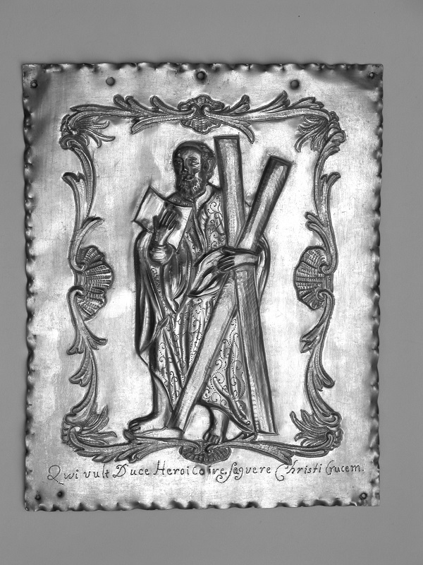 Plakietka prostokątna, repusowana, z wyobrażeniem stojącej postaci św. Andrzeja, z krzyżem w prawej i księgą w lewej ręce. Postać otoczona prostokątnym obramieniem z rokokowego ornamentu. W dolnej części grawerowania łacińska inskrypcja;''Oui vult Duce Heroico ive Sagvere Christi Crucem.